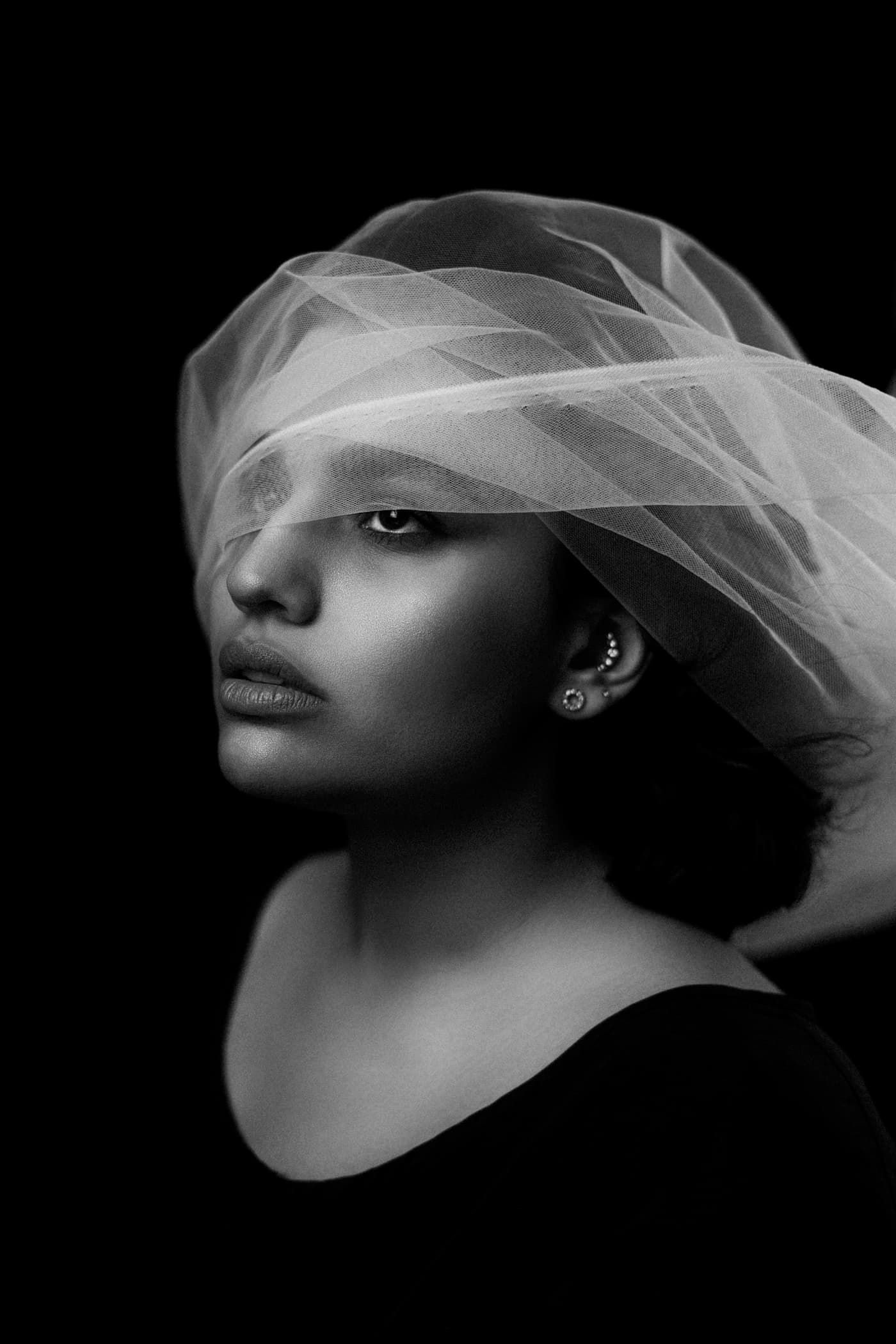 Portrait in black and white beneath a sheer veil